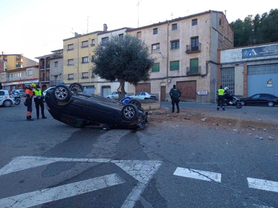 Los bomberos tienen que excarcelar al conductor de un vehículo que chocó y volcó en una rotonda en Alcañiz