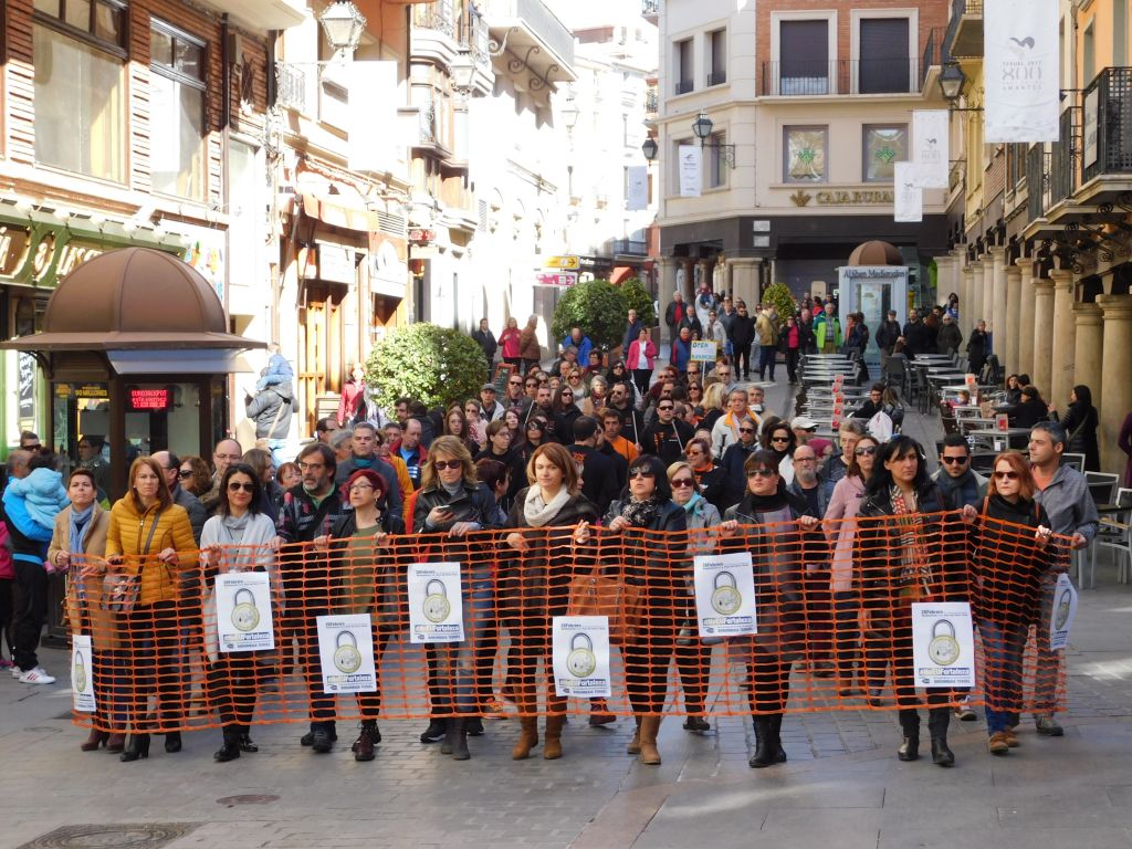 Una manifestación detrás de un muro simbólico recorre las calles de Teruel por los derechos de los desplazados