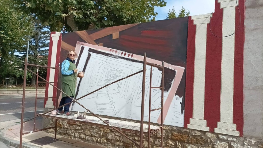 Irene Lario pinta el mural ‘Bocamina’ en la pared de una finca en Escucha