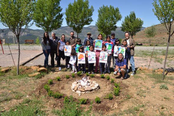 Los niños de Puertomingalvo plantan árboles para mejorar la zona del Punto Limpio