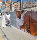 El artista Hugo Casanova decora el muro de las pistas deportivas del barrio turolense de San León