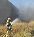Los bomberos apagan un incendio de neumáticos de tractor junto a una nave agrícola en Monreal