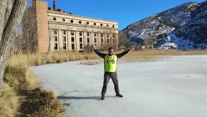 Un joven, sobre el pantano de Aliaga, solidificado, con la antigua central al fondo