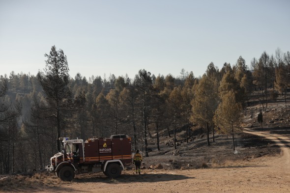 Bomberos en el retén mientras espera el relevo tras pasar la noche trabajando en el incendio en la zona de los Peiros, en la provincia de Teruel