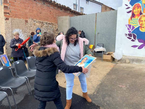 La alcaldesa (derecha), entregando una de las láminas a una de las vecinas